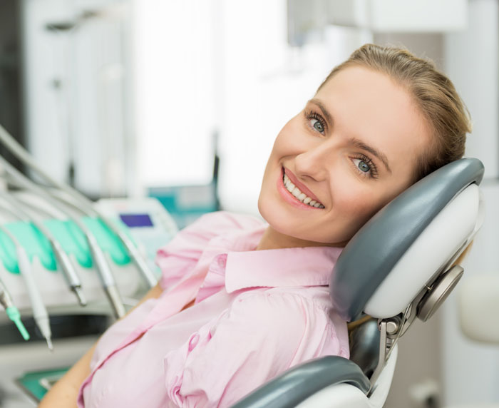 Women smiling sitting in a dental chair