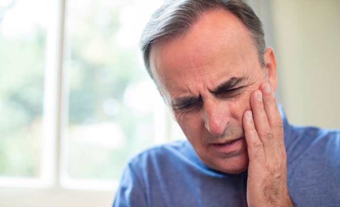 Man holding his jaw with a tooth ache